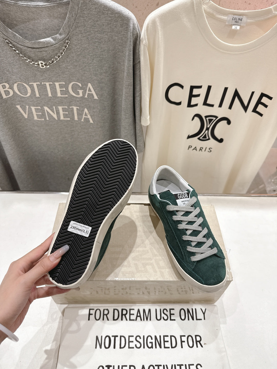 Golden Goose sneaker showing dark green suede upper and black treaded outsole