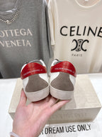 Back view of white sneakers with red heel lining held in hand