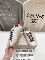 Handheld white sneaker with red heel lining, leopard lace overlay, and black star accent