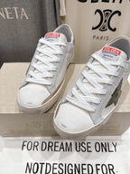Golden Goose luxury sneakers: white low-top sneakers with green star side patch and gold tab