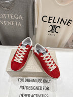 Golden Goose red sneakers with white laces and white sole on a display box