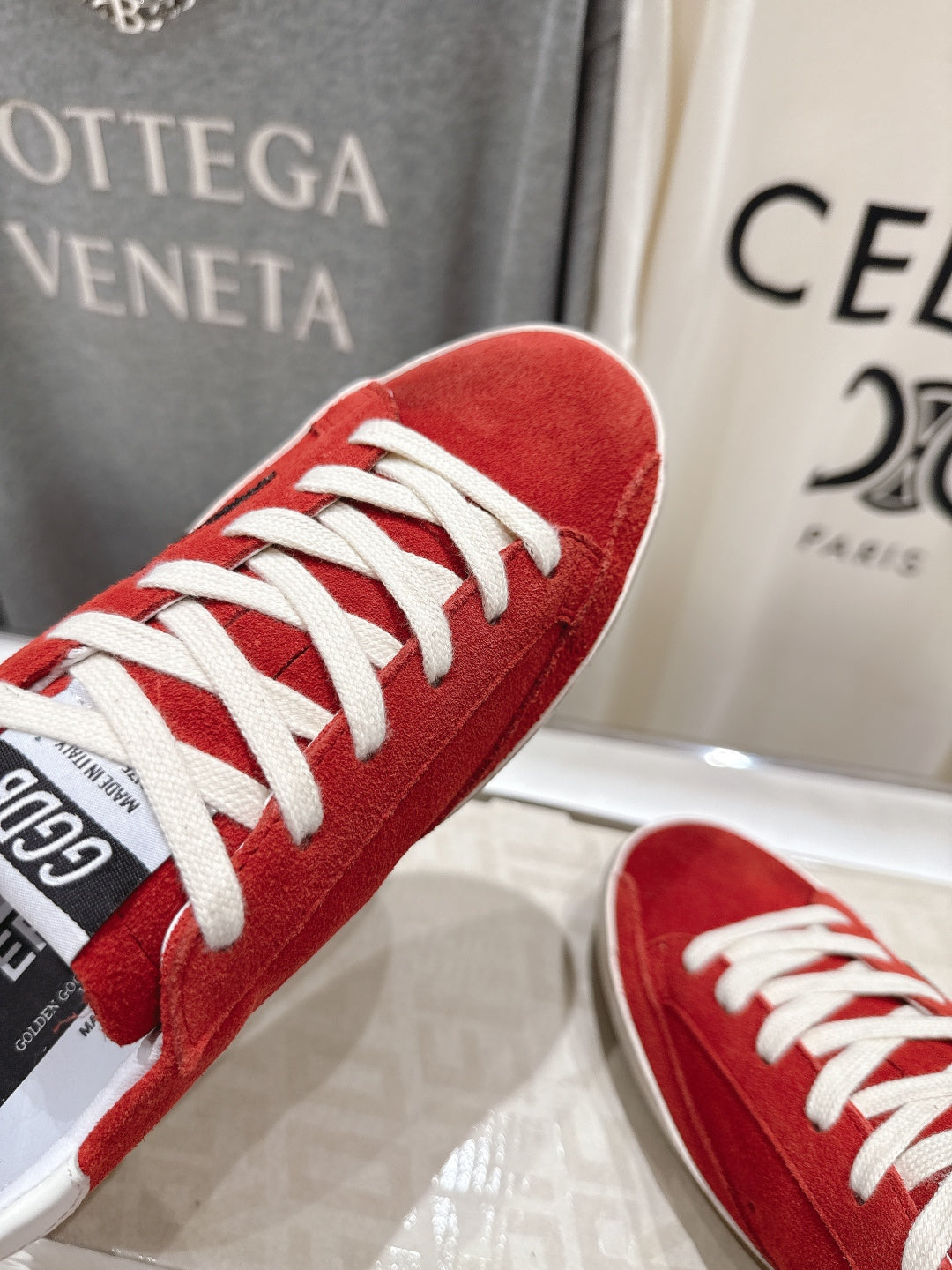 Golden Goose red sneakers close-up, white laces and toe cap, angled view