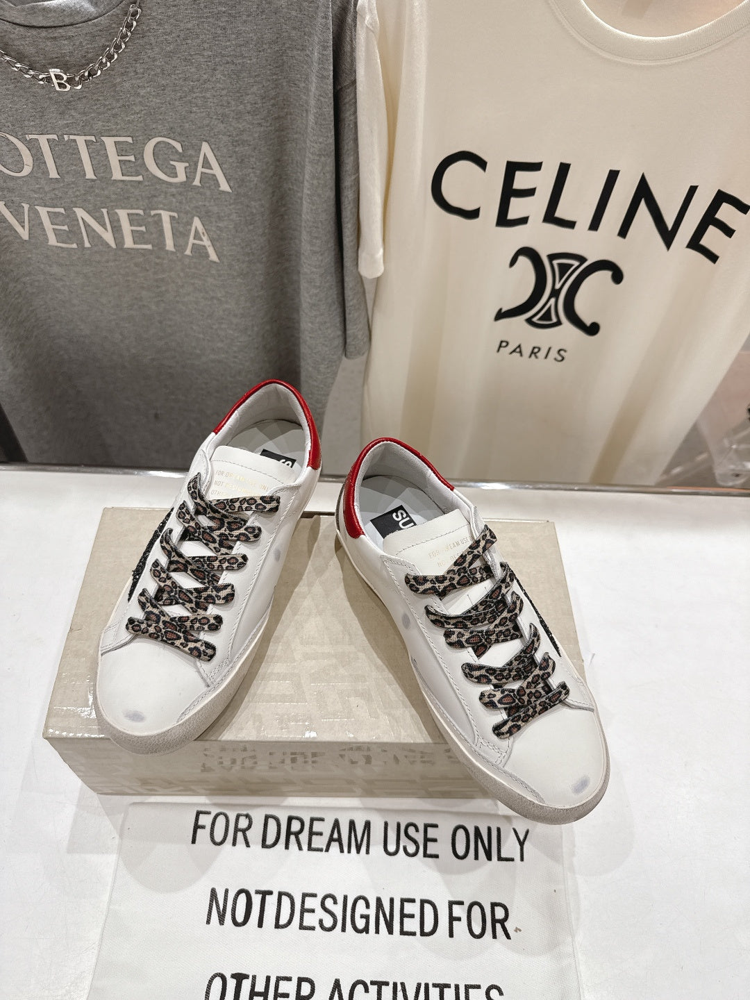 White sneakers with red collar, leopard-print lace overlay, and black star side detail