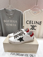 White low-top sneakers on a box, featuring leopard-pattern laces and black star patch
