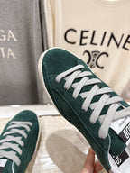 Close-up of dark green suede Golden Goose sneaker upper with white lace-up and trim