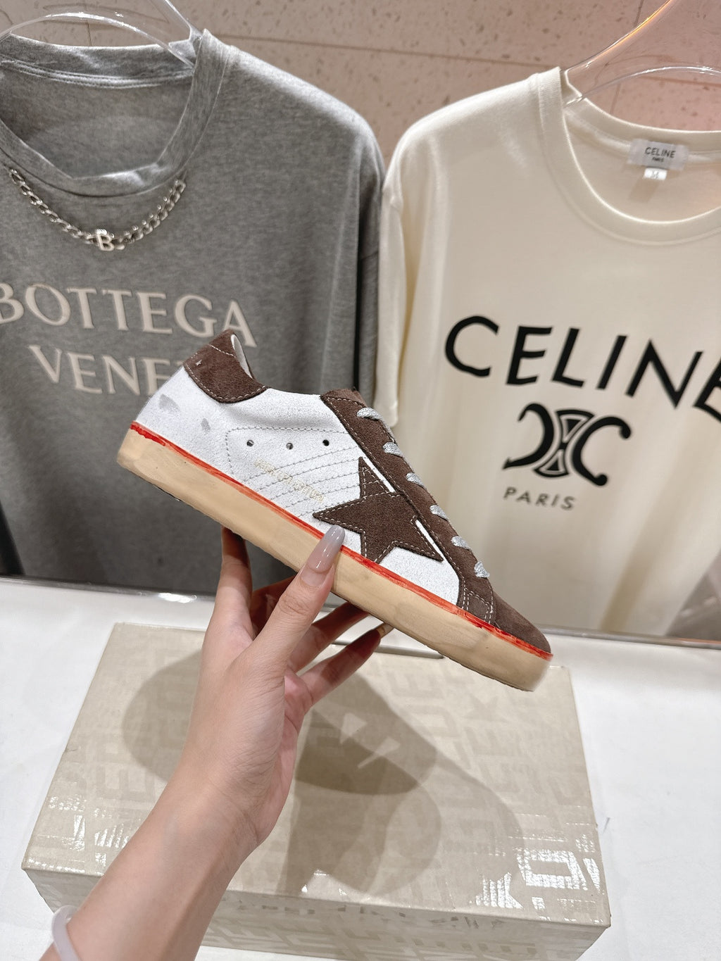Close-up of brown and white lace-up sneakers with white laces and red sole trim.