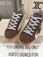 Front view of brown suede lace-up sneakers with white laces and red-trim cream soles.