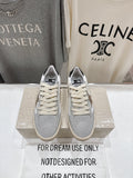 White and light gray sneakers with cream laces, on a display box