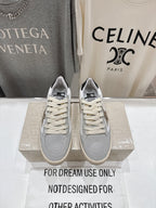 White and light gray sneakers with cream laces, on a display box