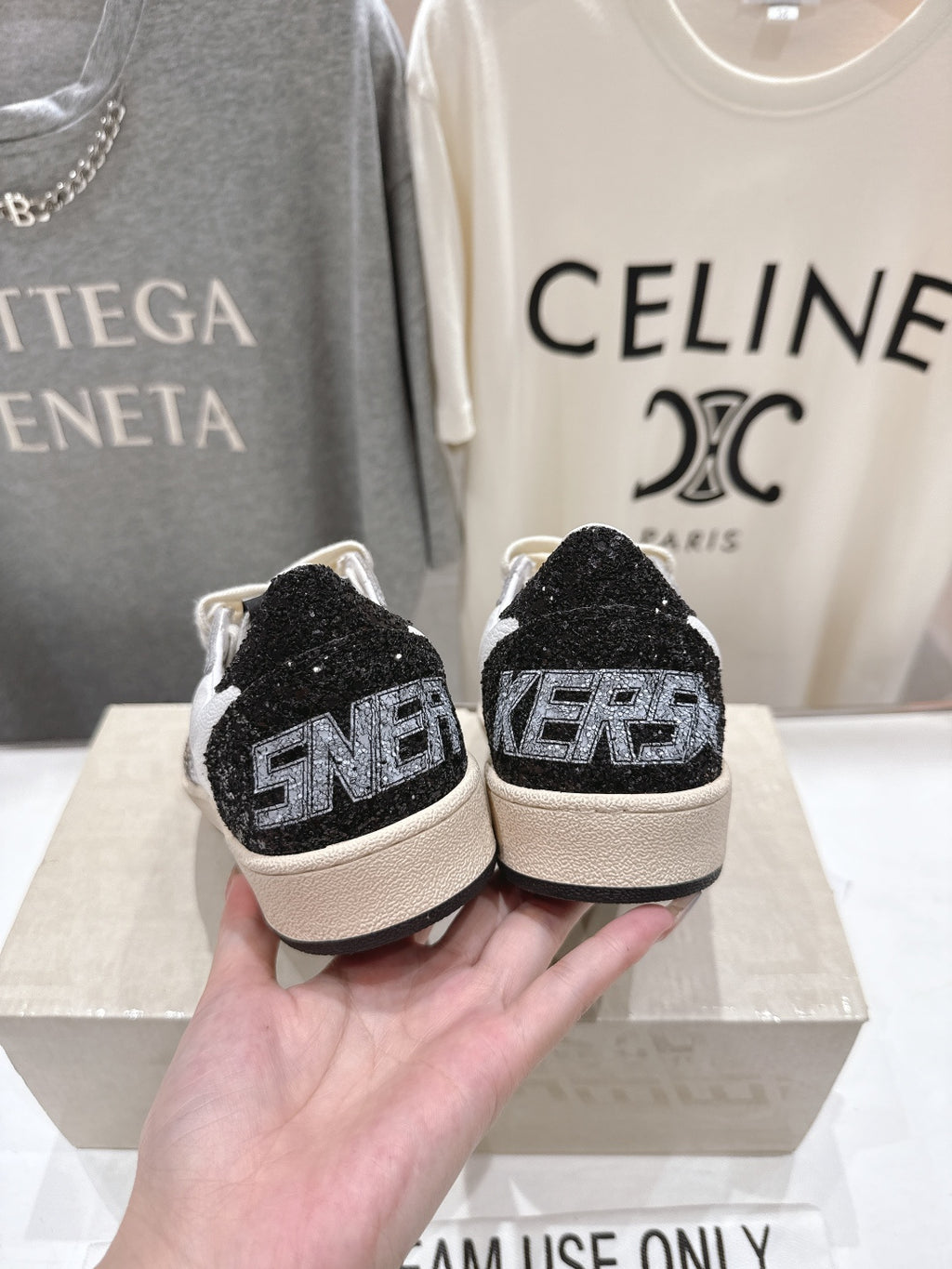 Back view of sneakers with black glitter heel tabs and cream laces
