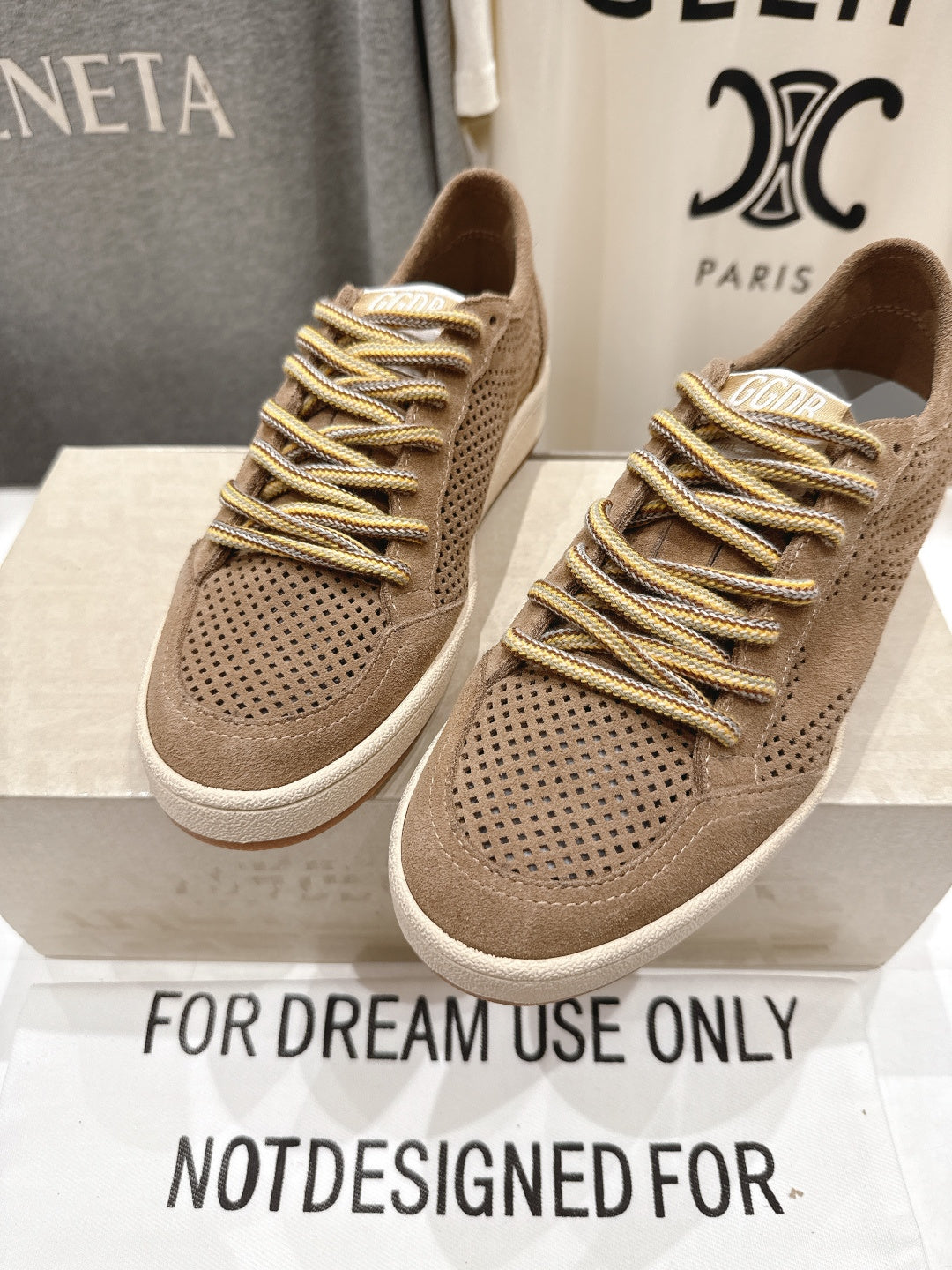 Tan low-top sneakers with perforated toe, gold laces and white cupsole