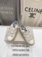 Pair of white lace-up low-top sneakers with multicolor side detailing and tan gum soles