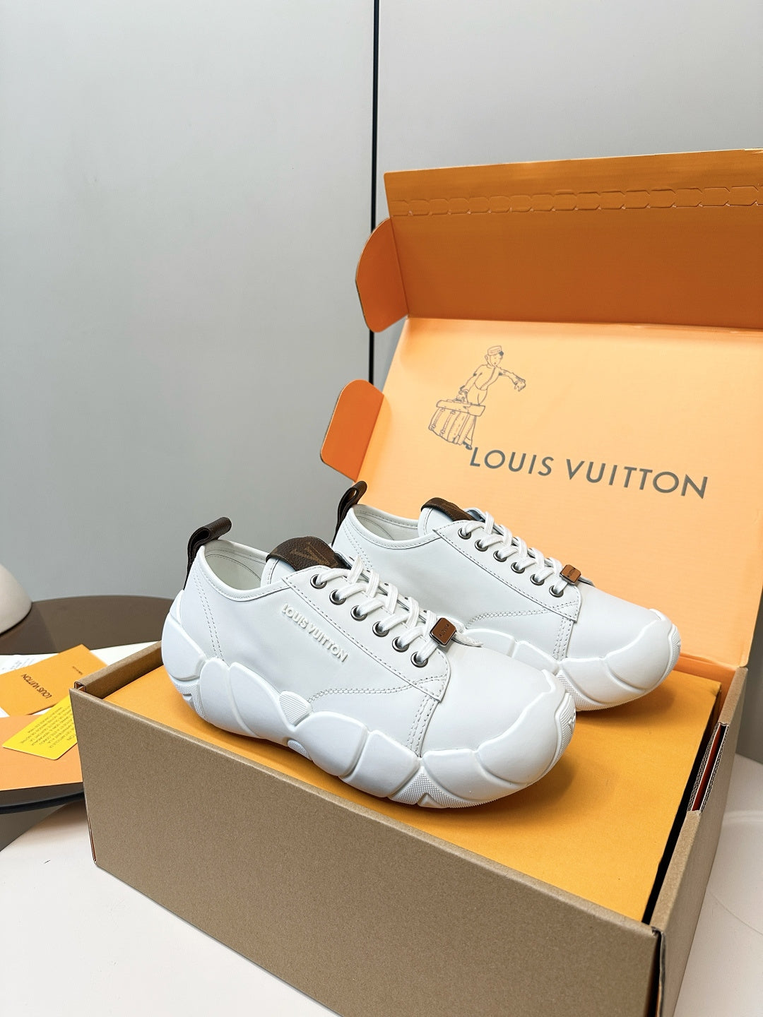 Pair of white low-top lace-up sneakers with dark heel patches and molded sole