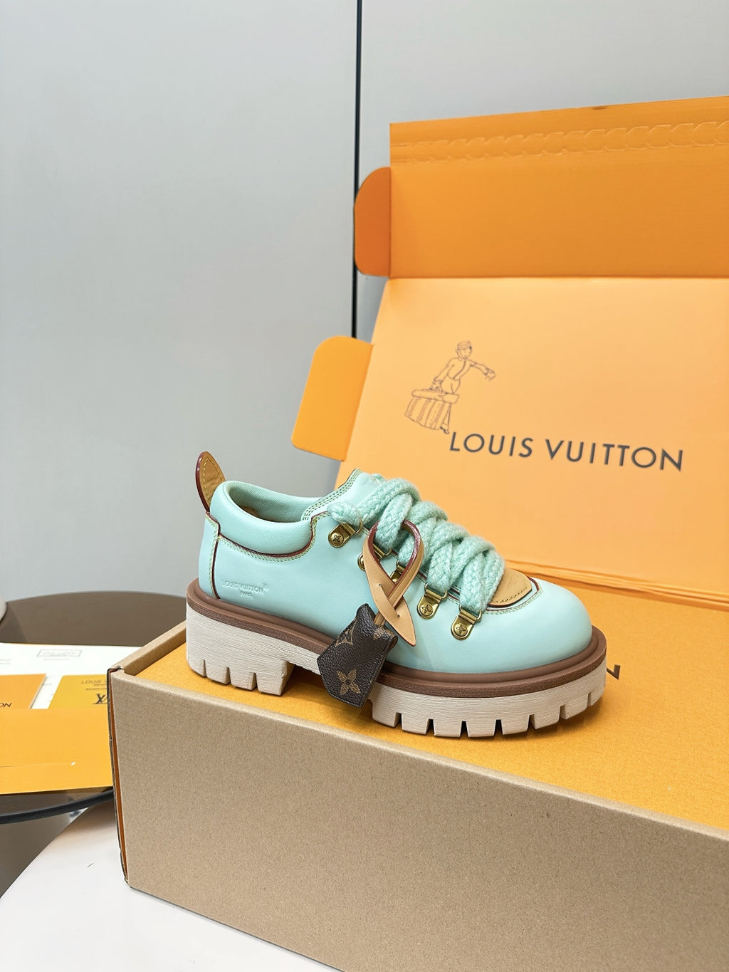 Louis Vuitton light blue lace-up sneaker with gold hardware and brown sole
