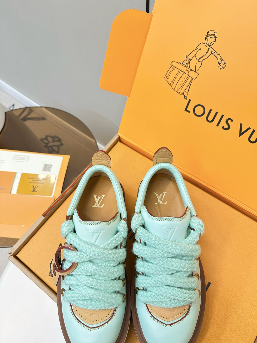 Louis Vuitton light blue sneakers with gold eyelets and brown-trimmed collar