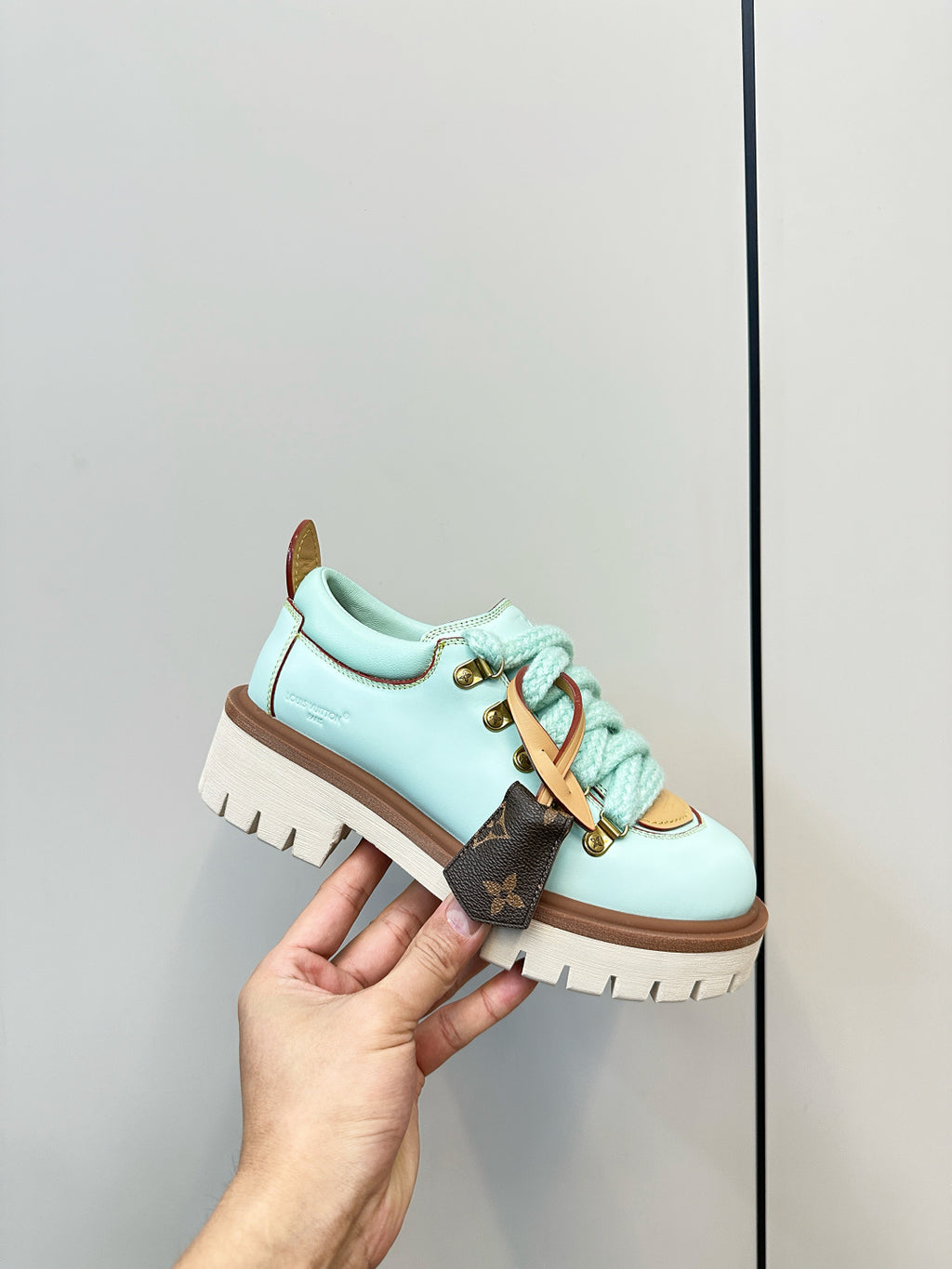 Louis Vuitton light blue lace-up sneaker with gold eyelets and brown-trimmed sole