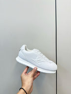 Louis Vuitton white lace-up sneaker close-up with hand holding shoe