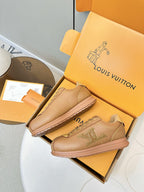 Tan lace-up low-top sneakers with LV side logo, pair shown outside box