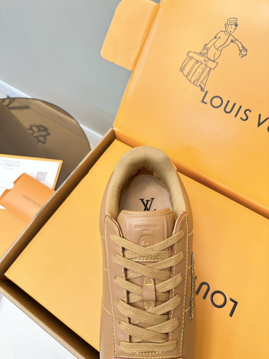 Tan lace-up sneaker with LV logo near tongue, padded collar and laces