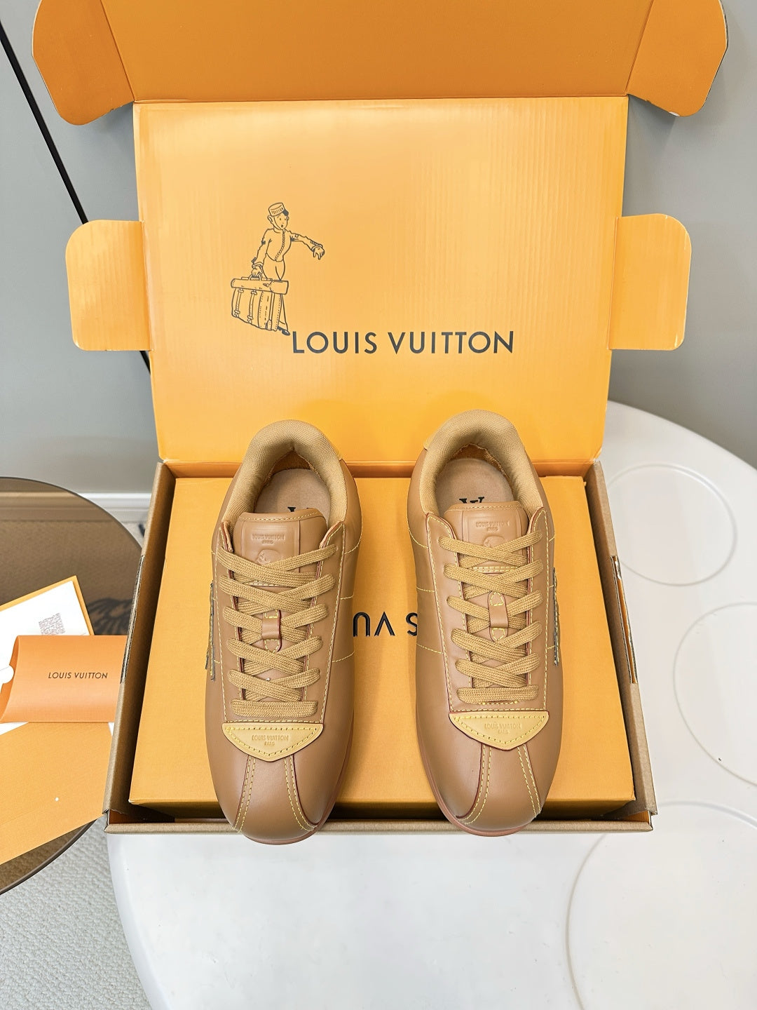 Tan lace-up low-top sneakers with LV logo on side, shown as a pair