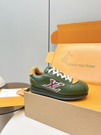 Green low-top sneaker on orange shoebox, white laces and red LV patch