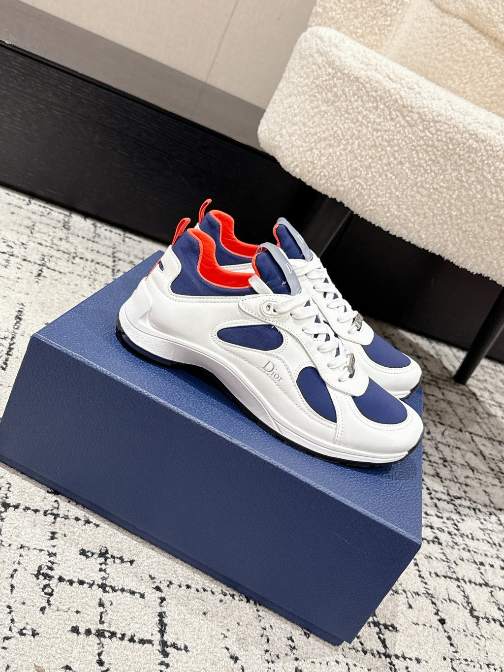 Unisex white and navy sneakers with red interior accents and white laces, Dior logo