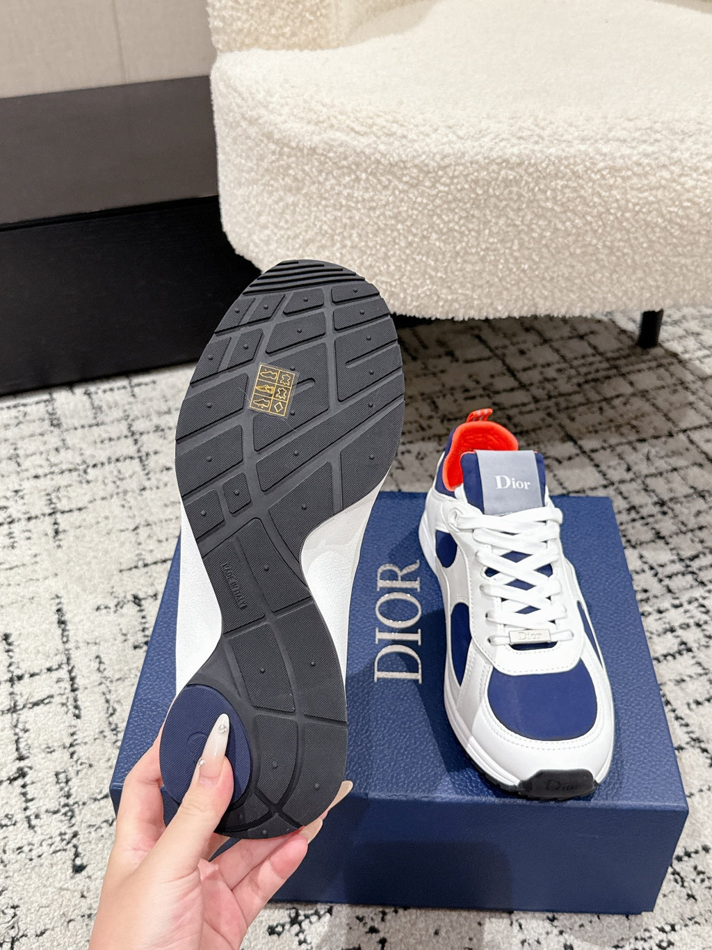 Unisex sneaker outsole and heel view: dark tread with white-and-navy upper, Dior logo