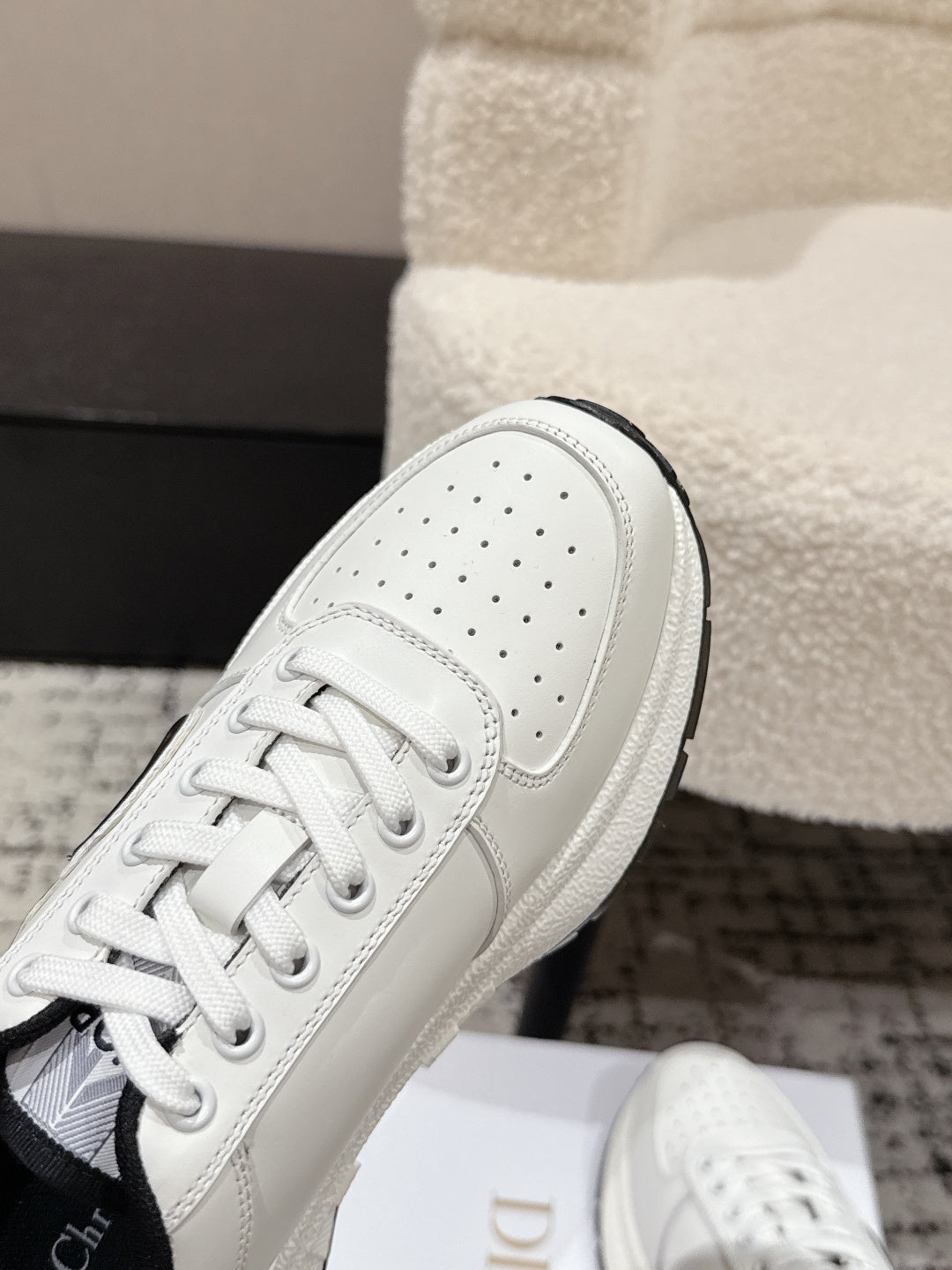 White leather sneaker upper with perforations and lace-up front close-up