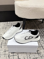 Pair of white low-top sneakers on display box with black collar accents