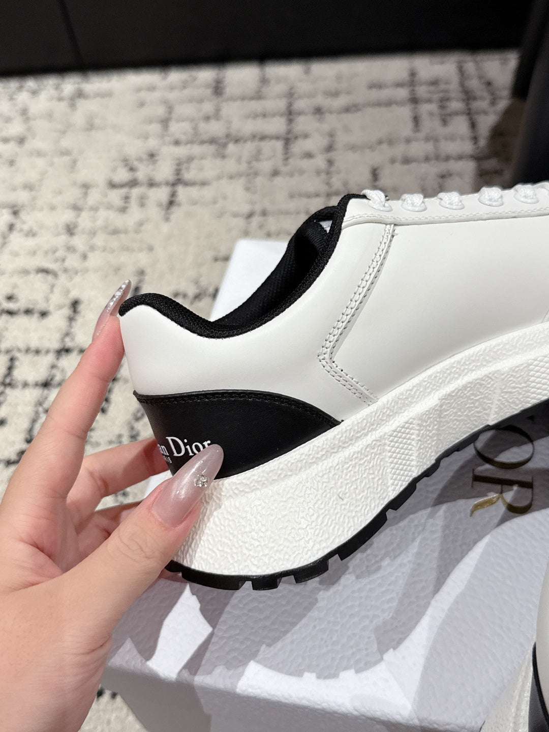 White sneaker with black collar trim and thick white sole; side view