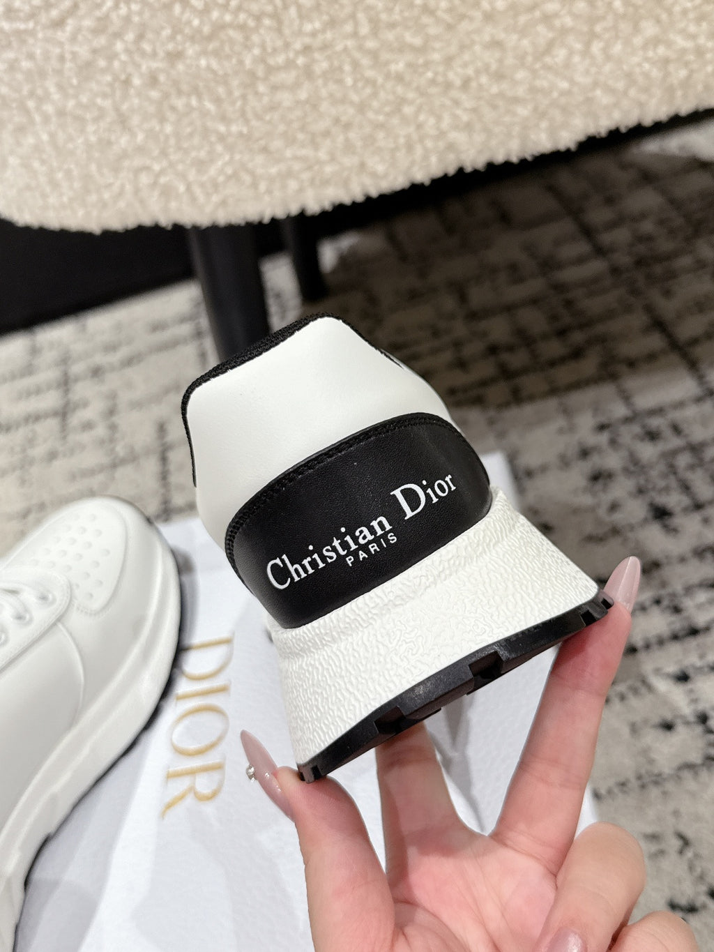 White sneaker with black tongue label reading 'Christian Dior Paris'