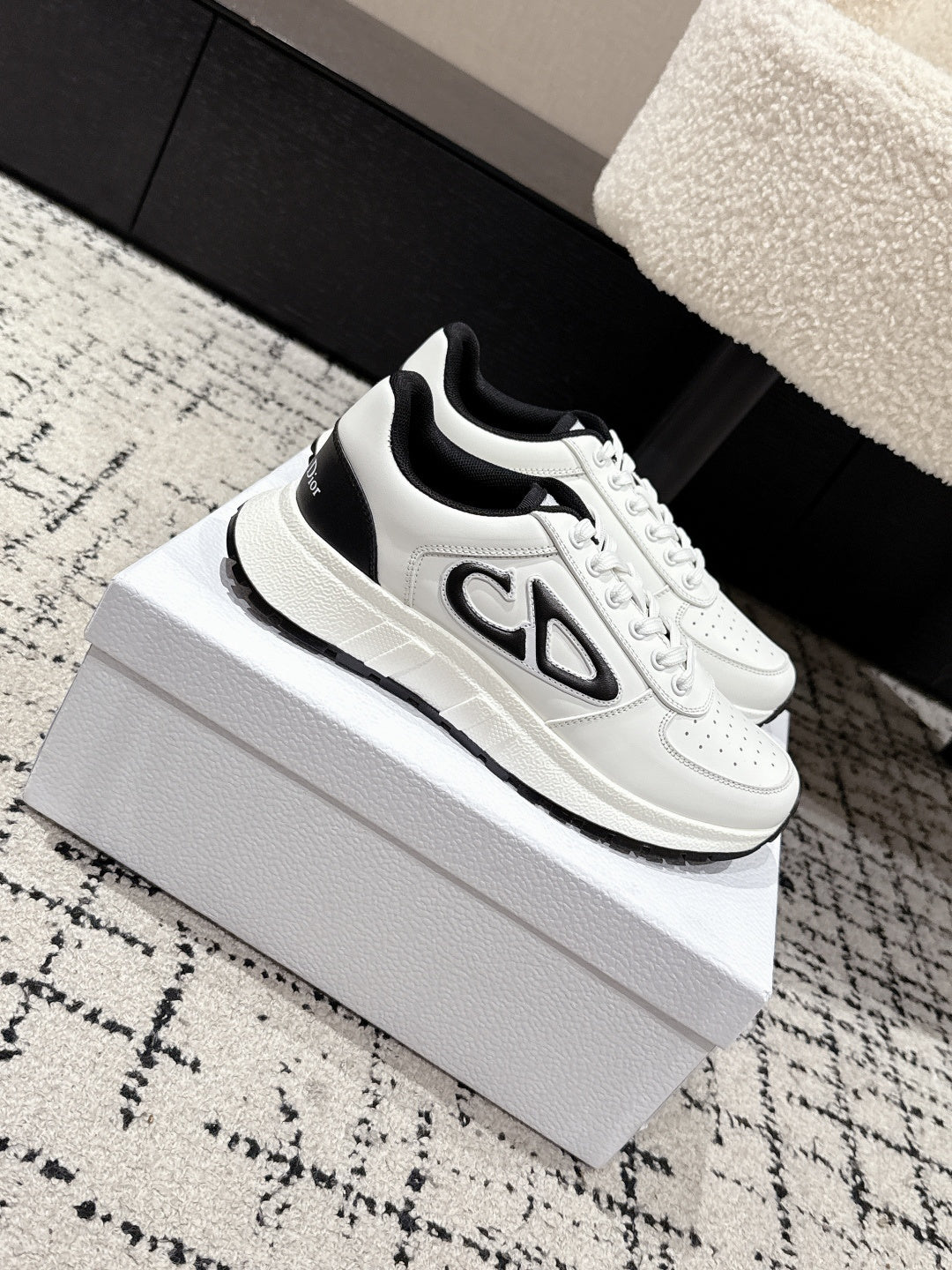 White low-top sneakers with black trim and bold 'CD' logo panel