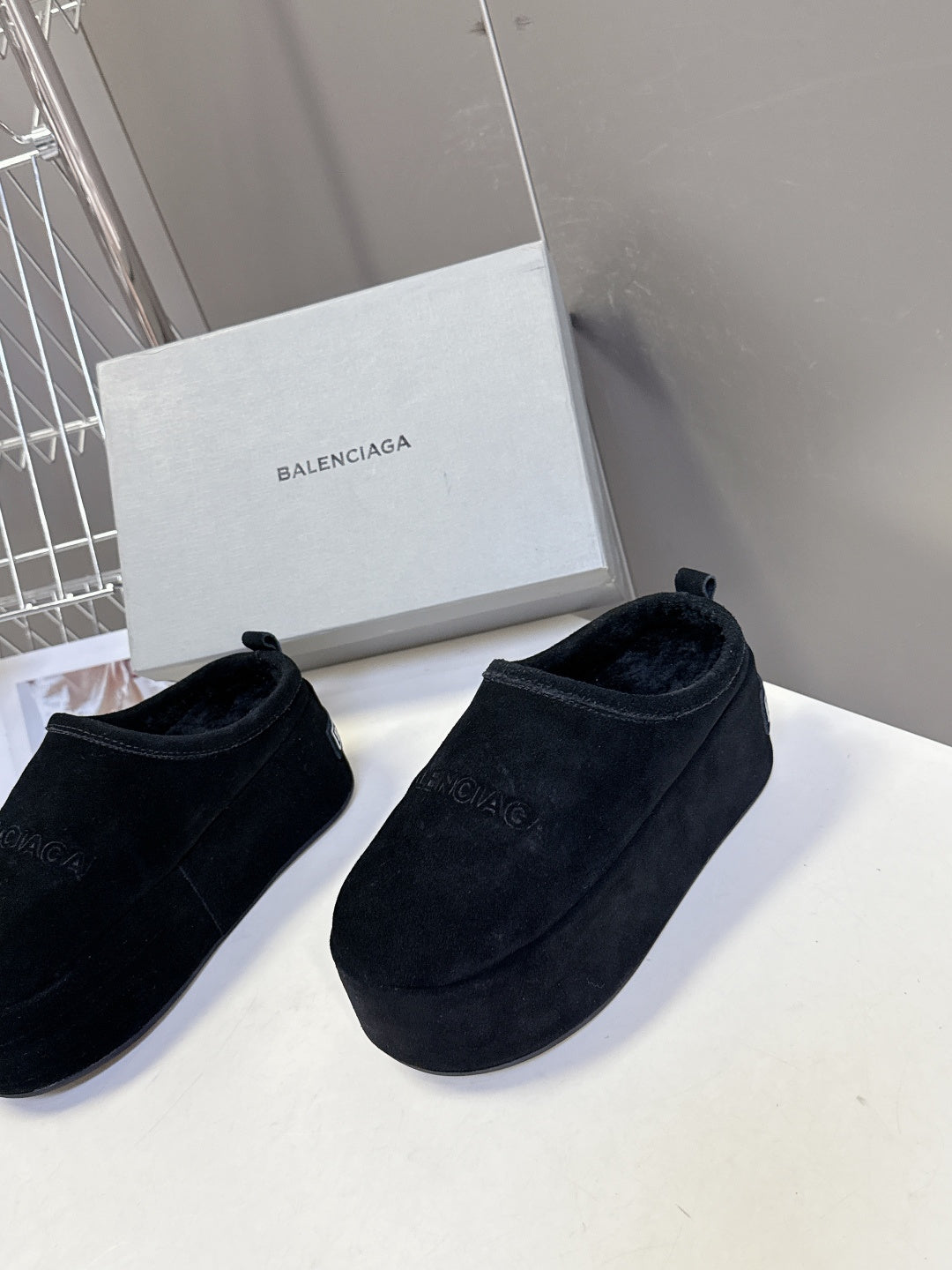 Balenciaga black suede slip-on sandals, angled view with logo detailing