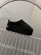 Balenciaga black suede slip-on sandals on display rack, side profile