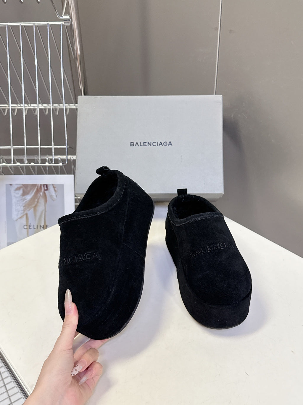 Balenciaga black suede slip-on sandals, held up for a side-by-side view