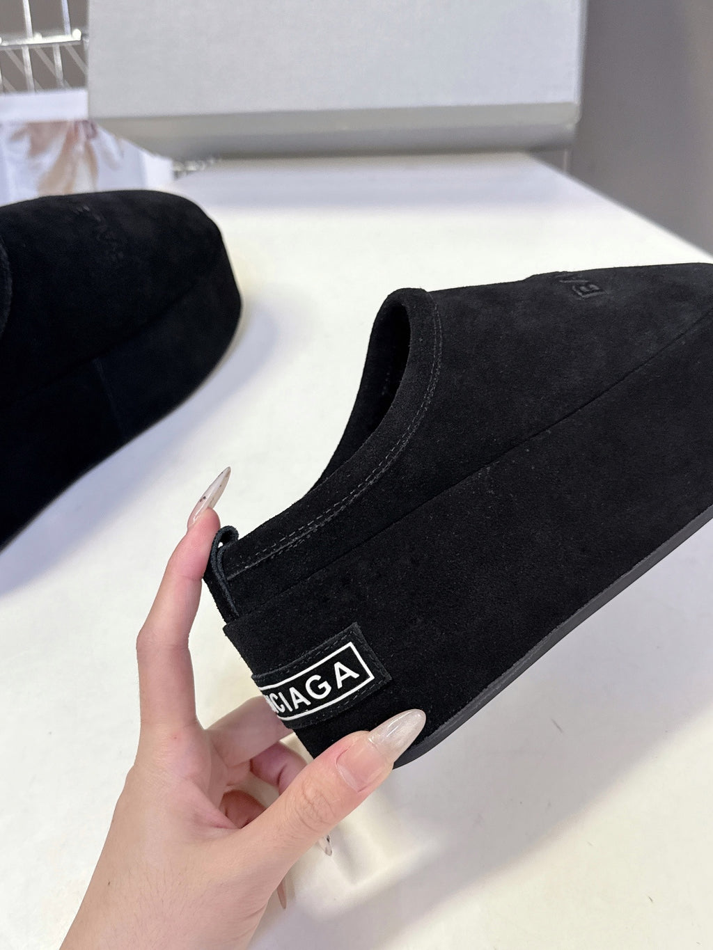 Balenciaga black suede slip-on sandal close-up with BALENCIAGA logo label