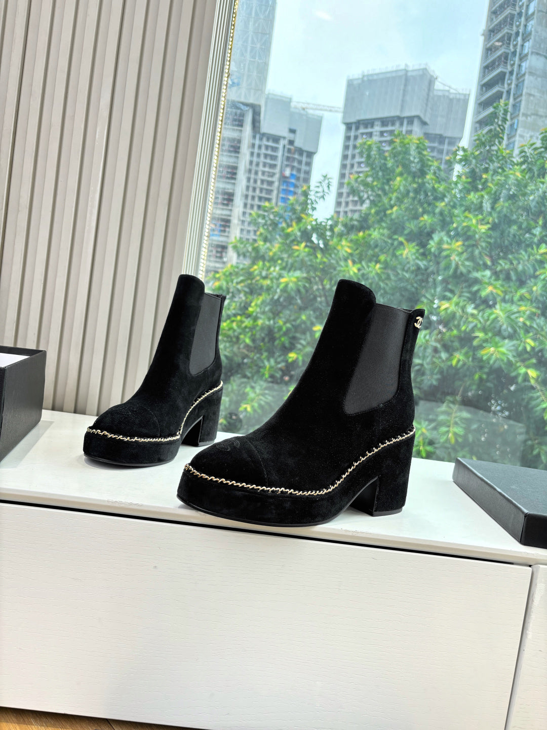 Black suede ankle boots with side pull tabs and chunky heel, chain-stitch trim