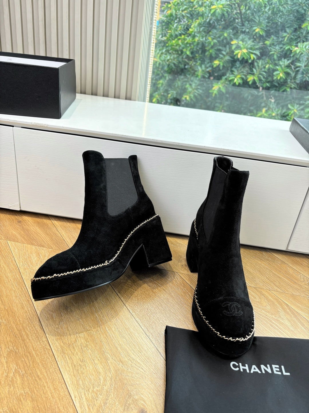 Black suede ankle boots with chunky heel and chain-stitch trim, side view