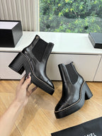 Black Chelsea ankle boots with block heels, side elastic, and small emblem