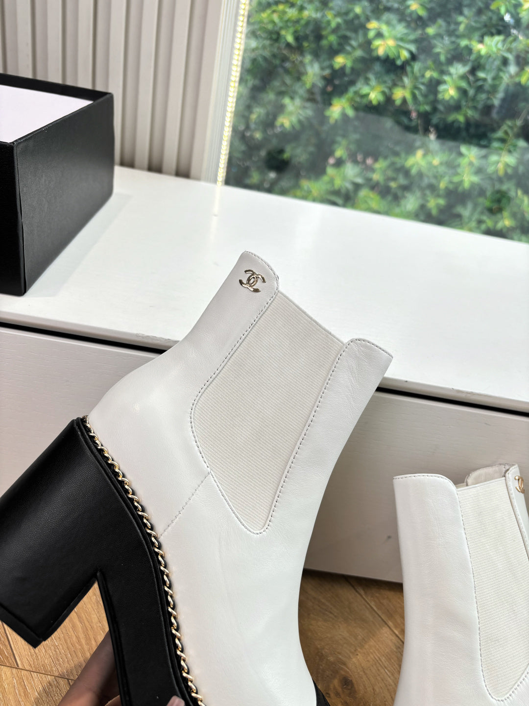 White Chelsea boots with side elastic, contrast stitched trim, and logo badge