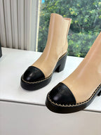 Beige ankle boots with black toe cap and block heel, side view