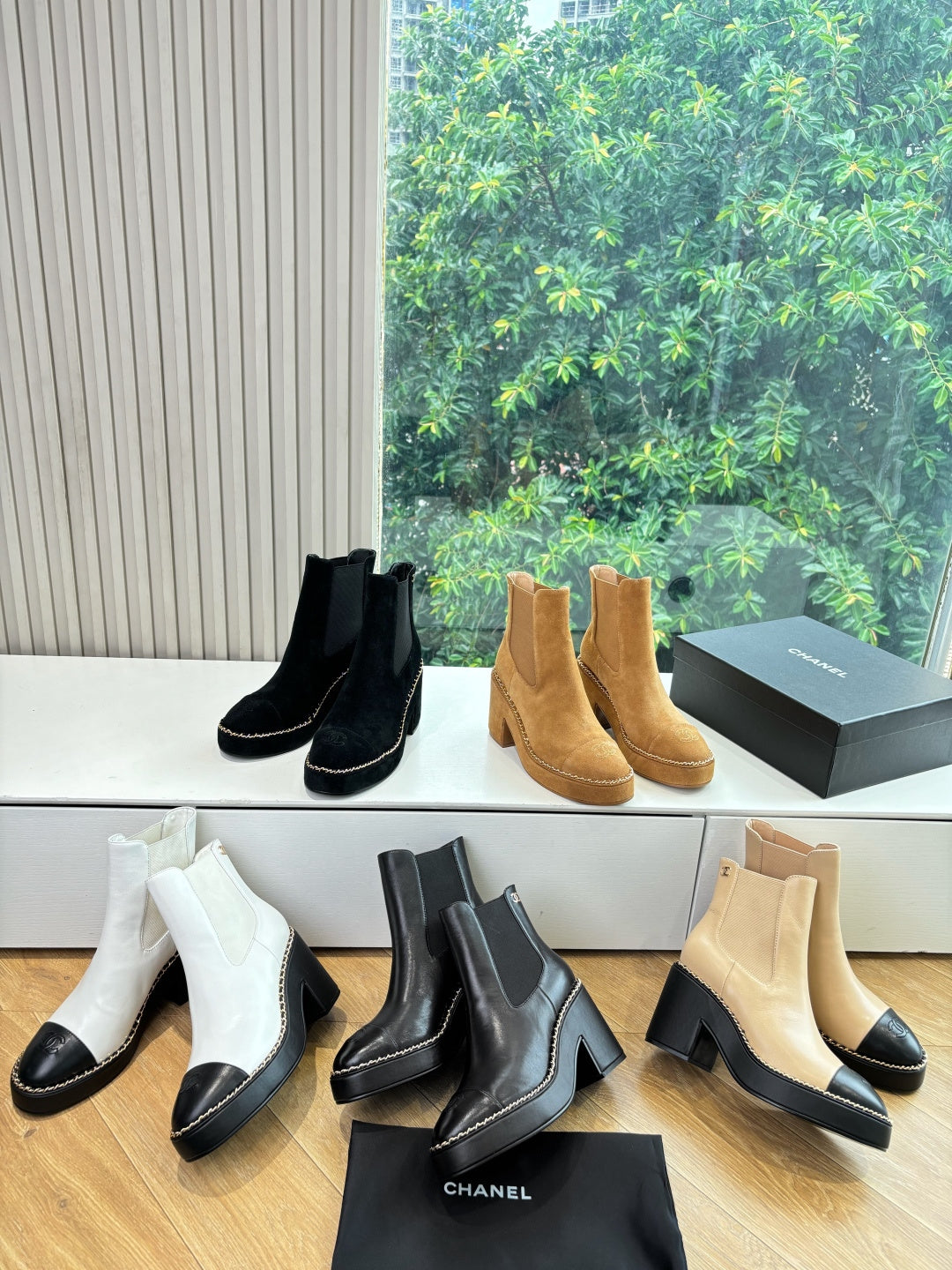 Women’s ankle boots display: white, black, and tan Chelsea styles with block heels