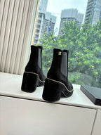 Black suede ankle boots with chunky heel and gold CC logo on side