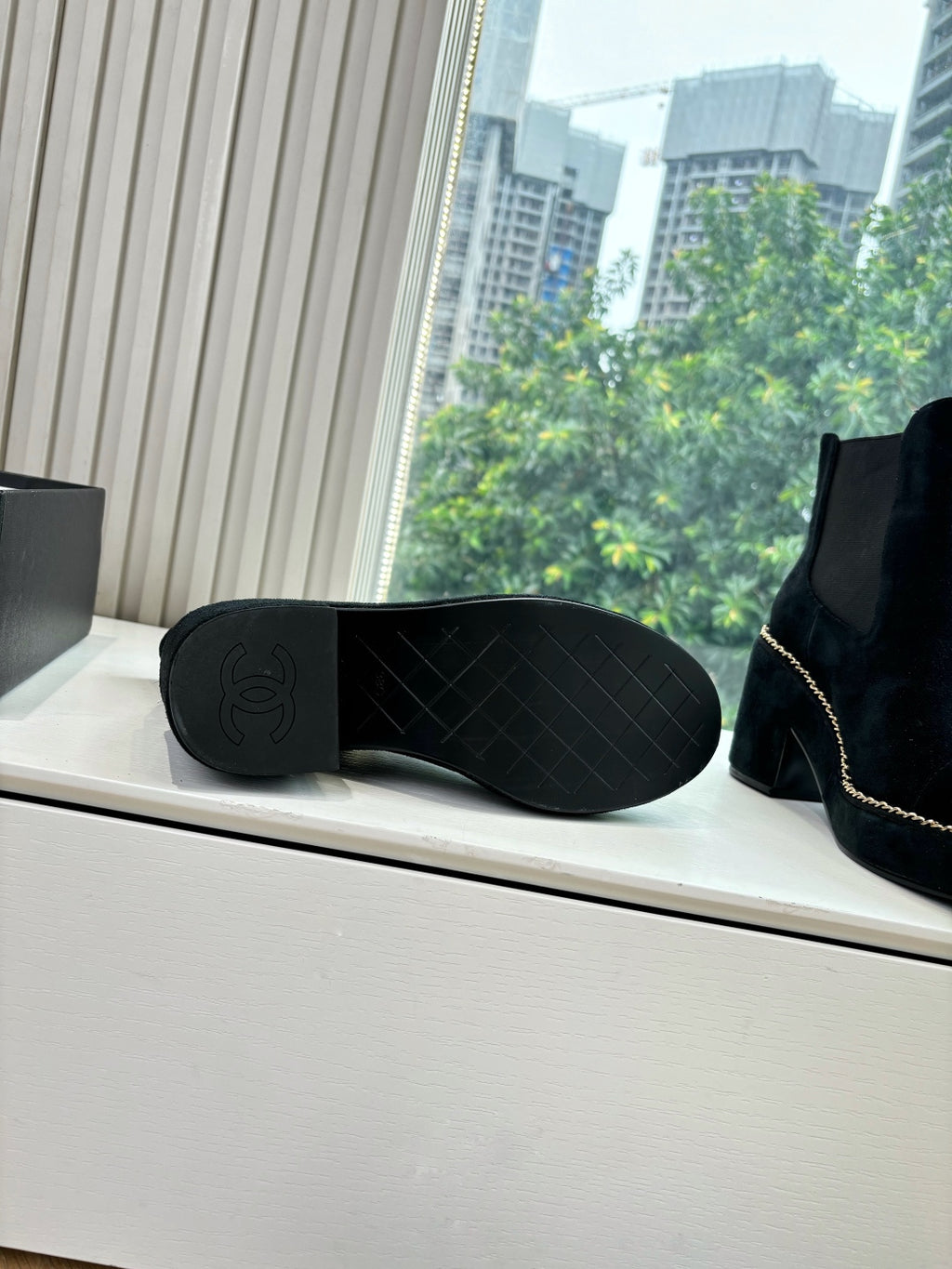Black suede ankle boots showing quilted outsole and chain-stitch trim