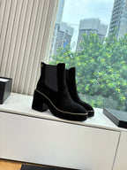 Black suede ankle boots with square toe, chunky heel, and chain-stitch edging