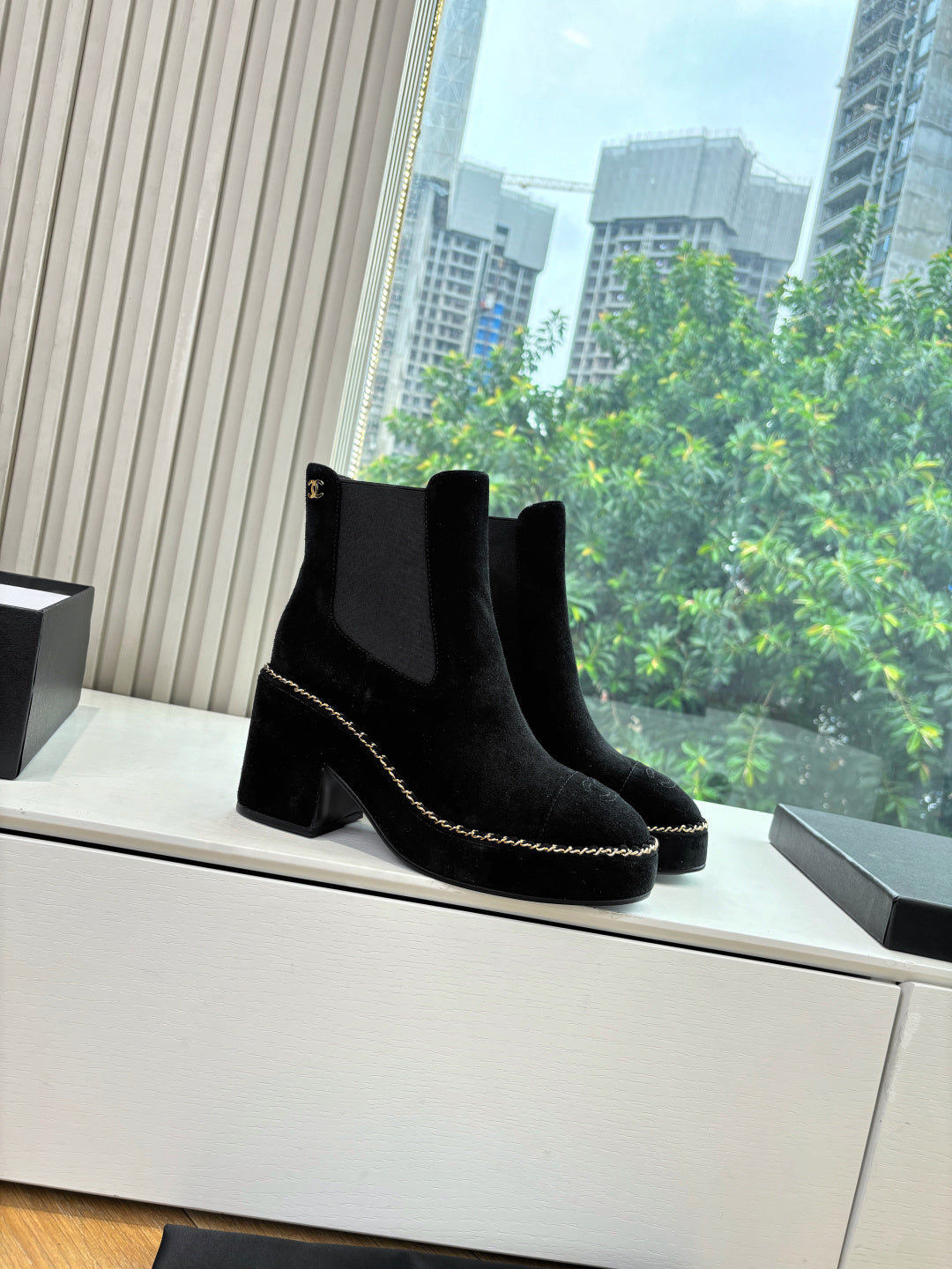 Black suede ankle boots with square toe, chunky heel, and chain-stitch edging