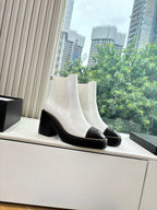 White ankle Chelsea boots with black rubber sole, contrast trim, and block heel