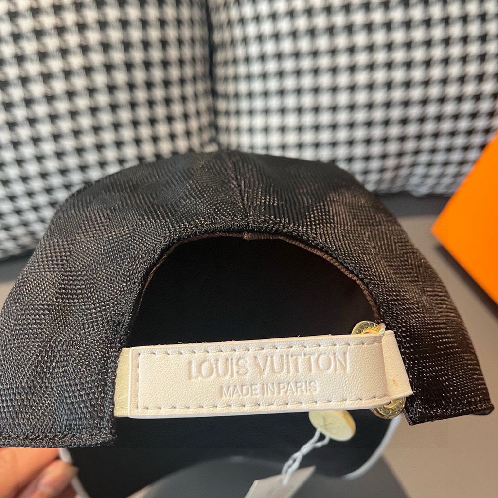 Dark gray baseball cap underside with white Louis Vuitton label and hanging tag