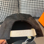 Dark gray baseball cap underside with white Louis Vuitton label and hanging tag