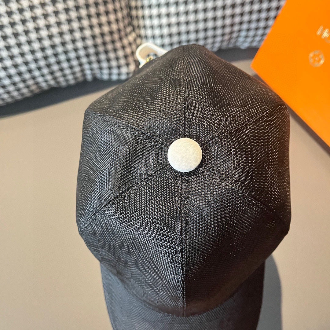Dark baseball cap with curved brim and round white top button